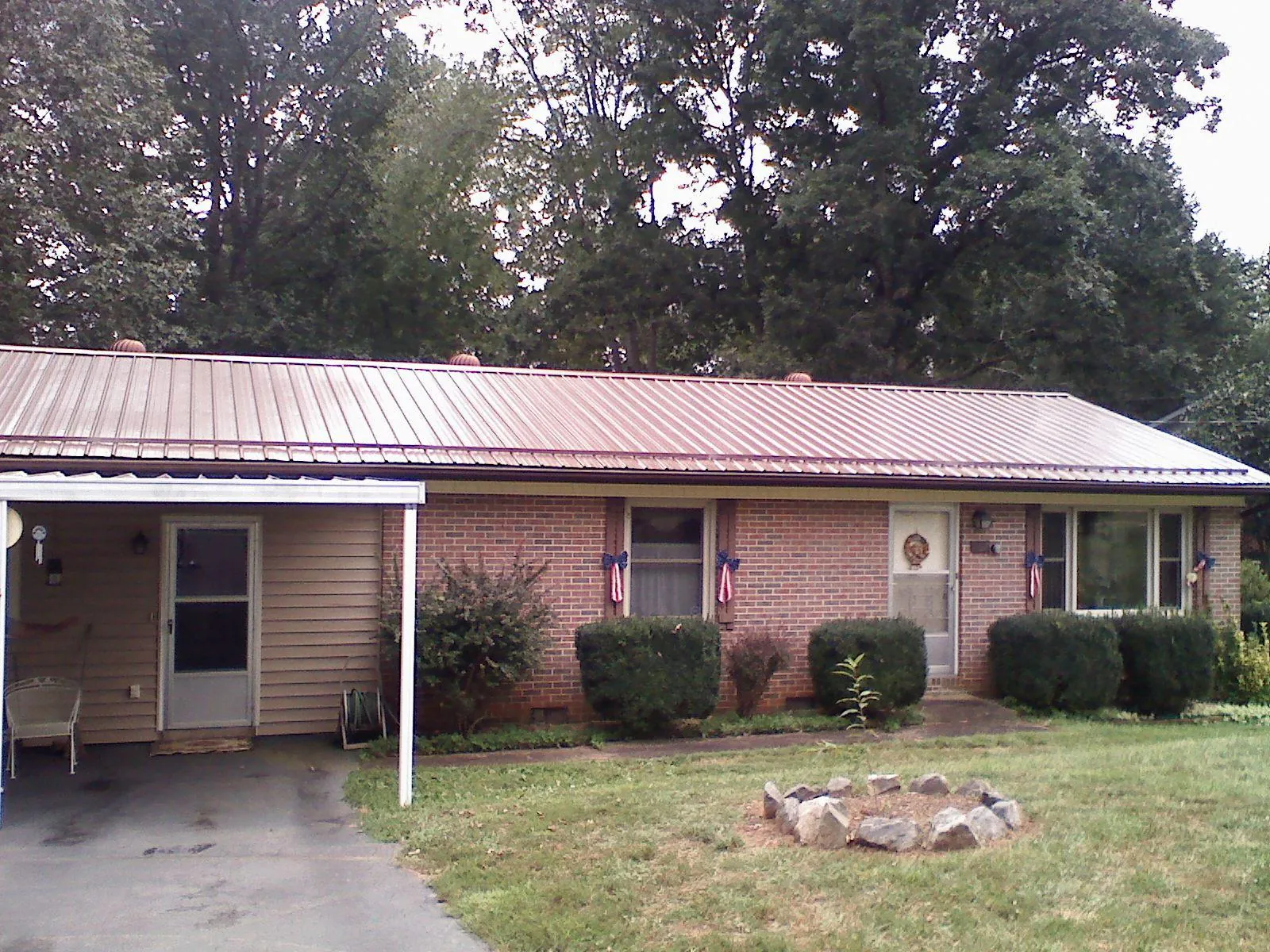 Bronze metal roof and carport on a brick ranch home — Roof Repair work by our crew in Plain Dealing