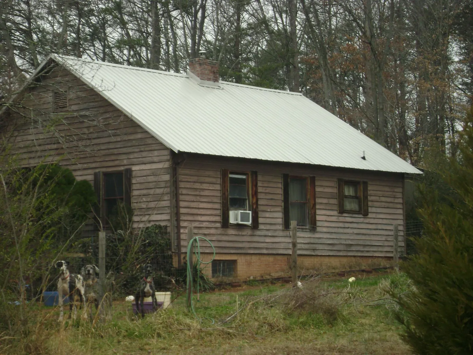 White metal roof on an old wood sided farmhouse, from a Metal Roof Installation job in Plain Dealing